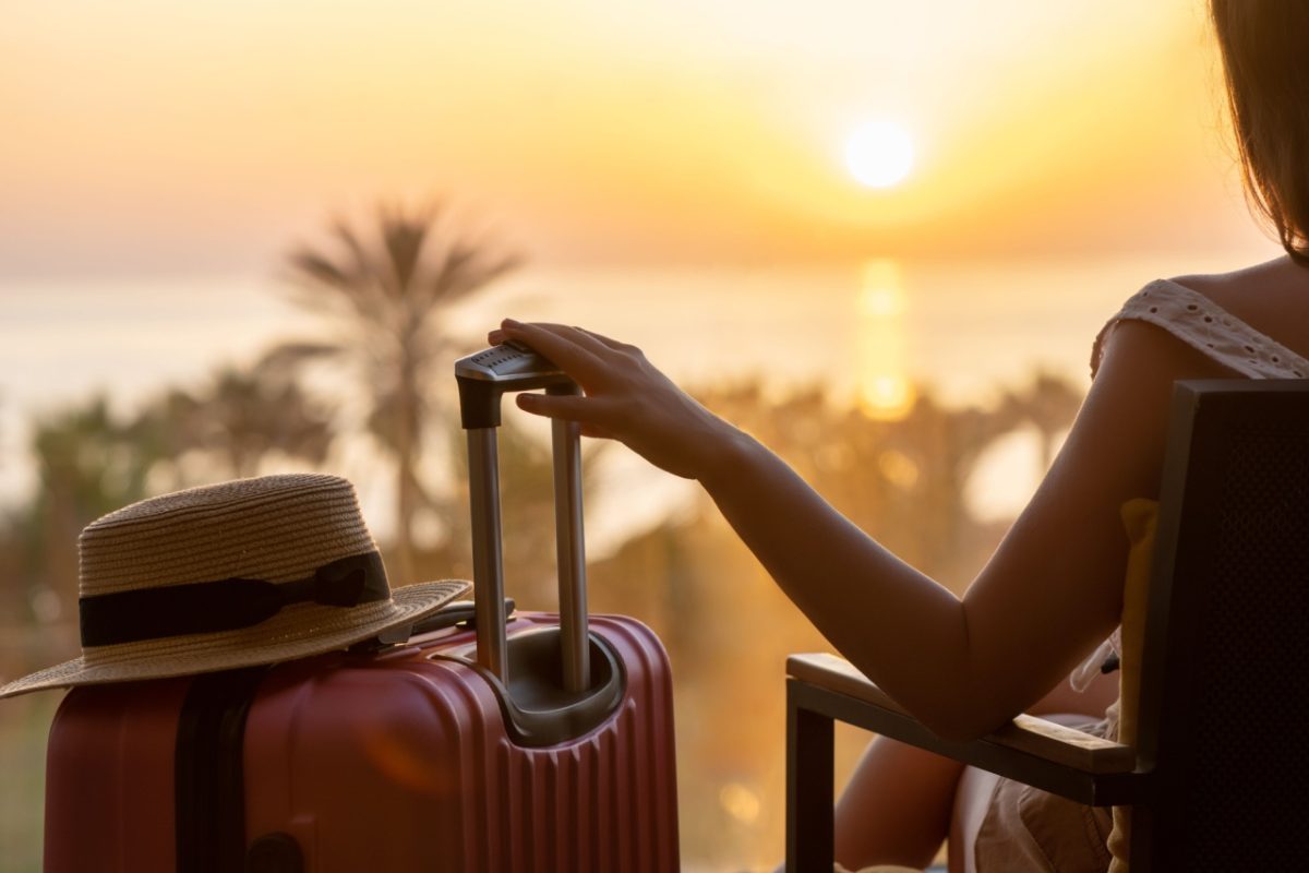 A woman sitting with a suitcase.