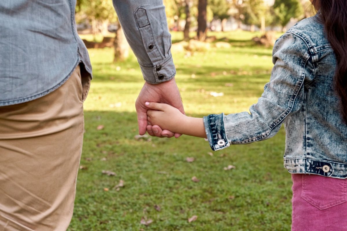 Parent and child holding hands.