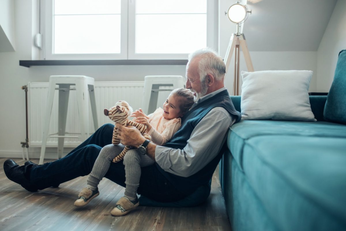 A grandfather playing with his granddaughter.